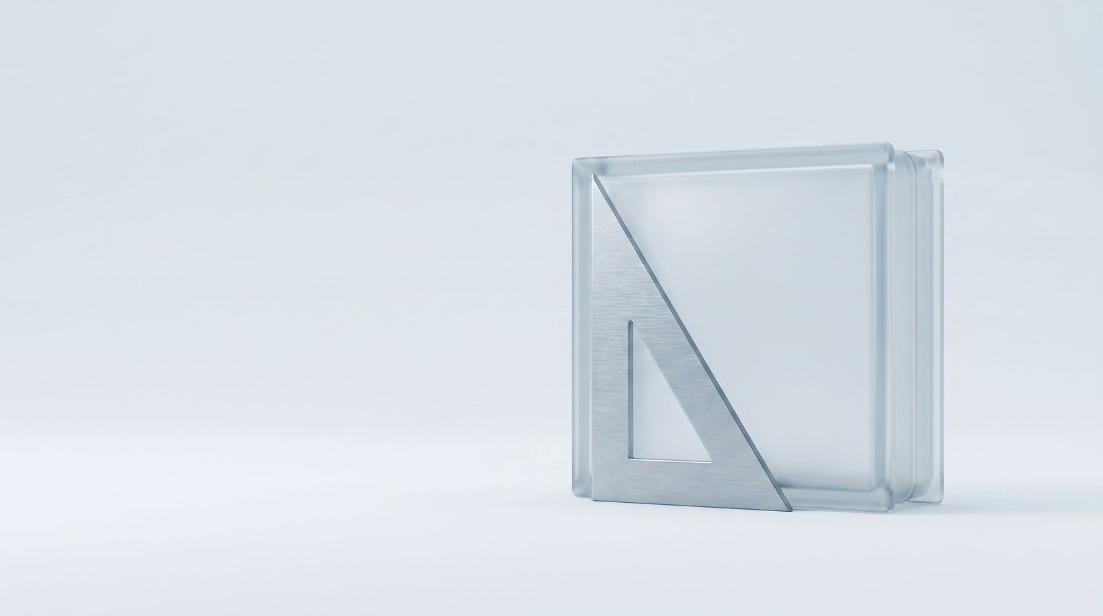 A steel engineer's set square resting flush against a frosted glass block