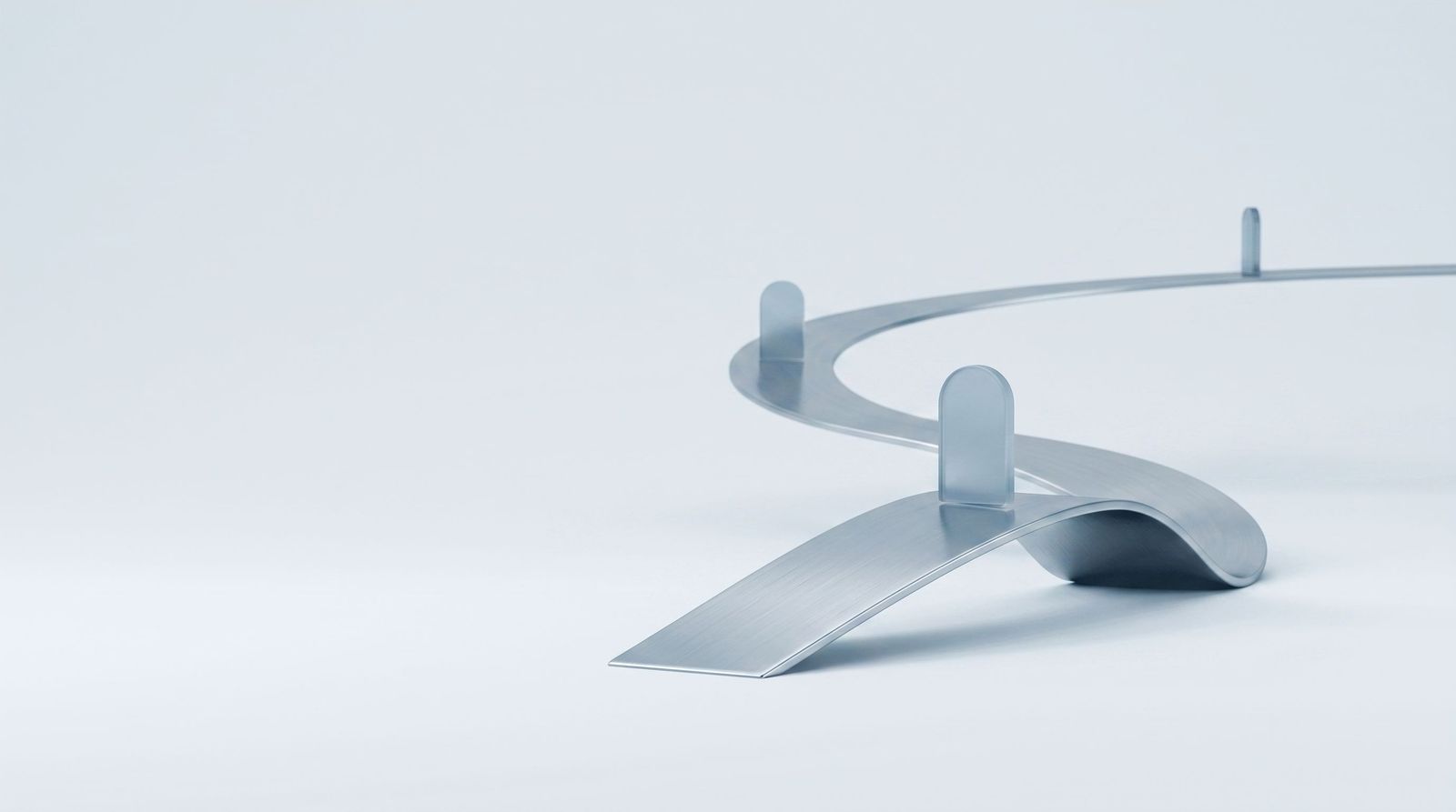 A steel ribbon curving into the distance with glass markers along its length