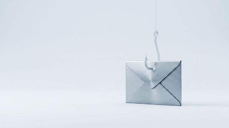 A brushed steel envelope with a glass fish hook resting on its seal