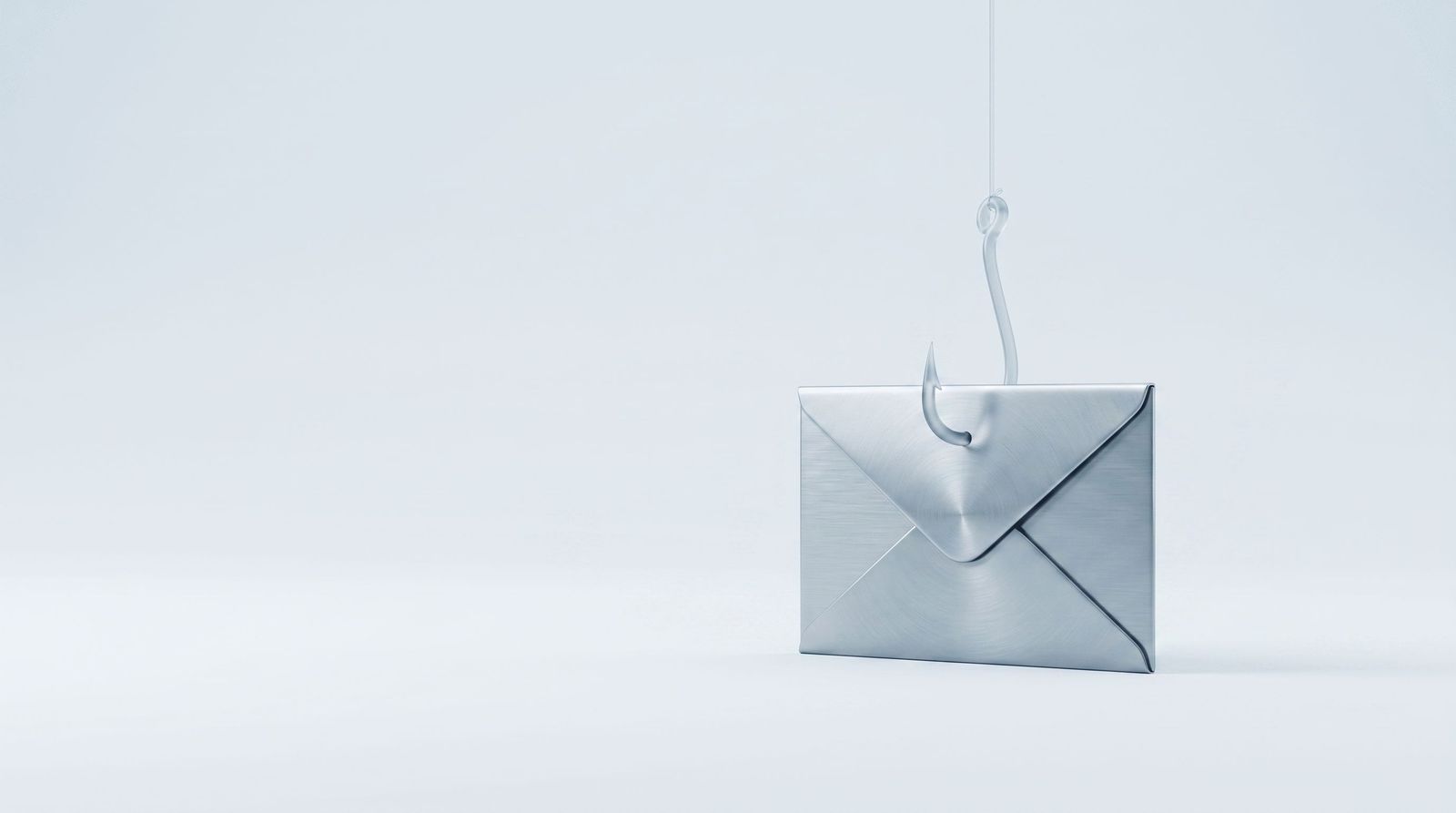 A brushed steel envelope with a glass fish hook resting on its seal