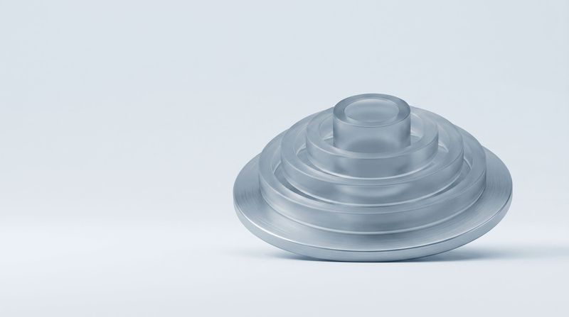 A steel disc with concentric glass rings rising from it like a contour map